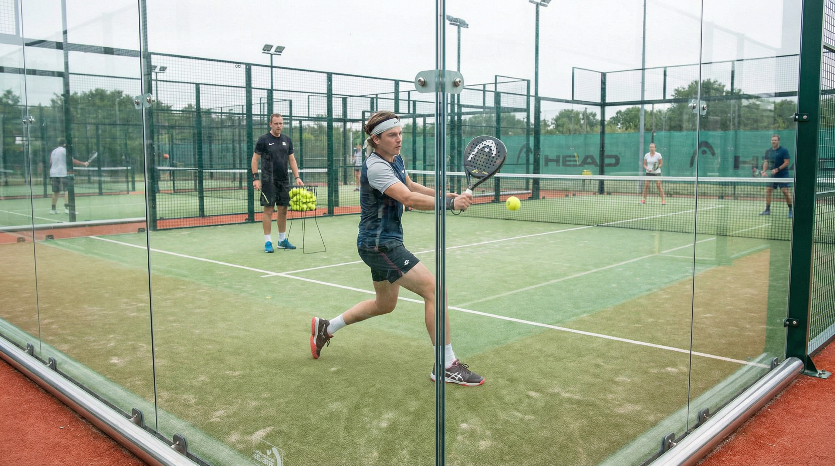 Padel player training with glass rebounds