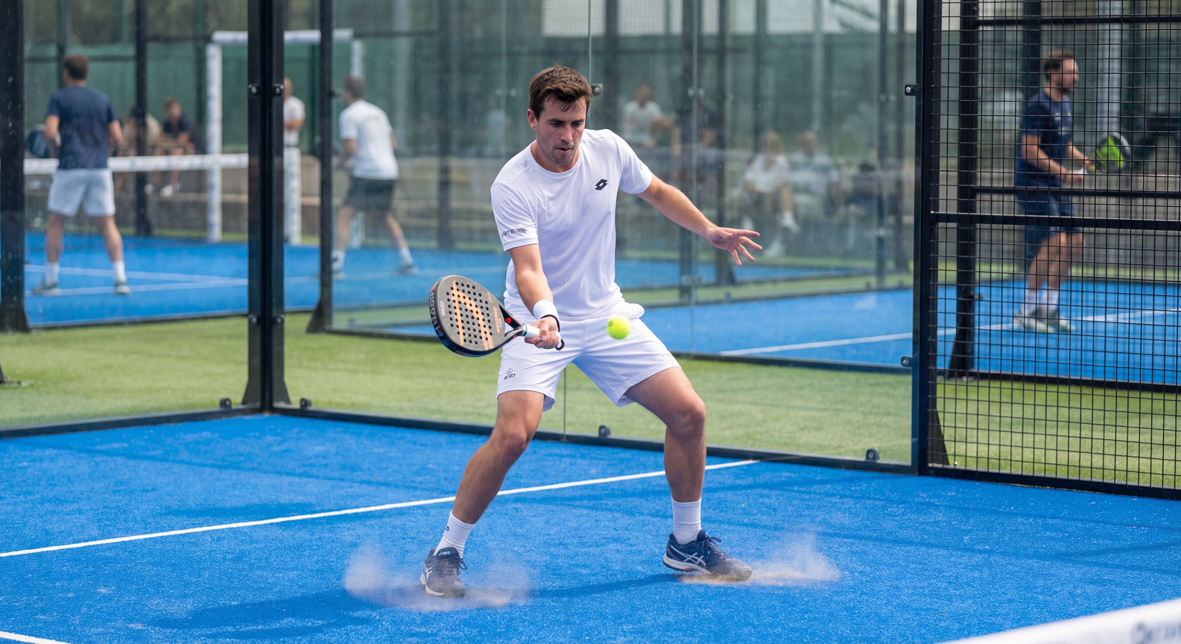 A player preparing an underhand serve near the back wall.