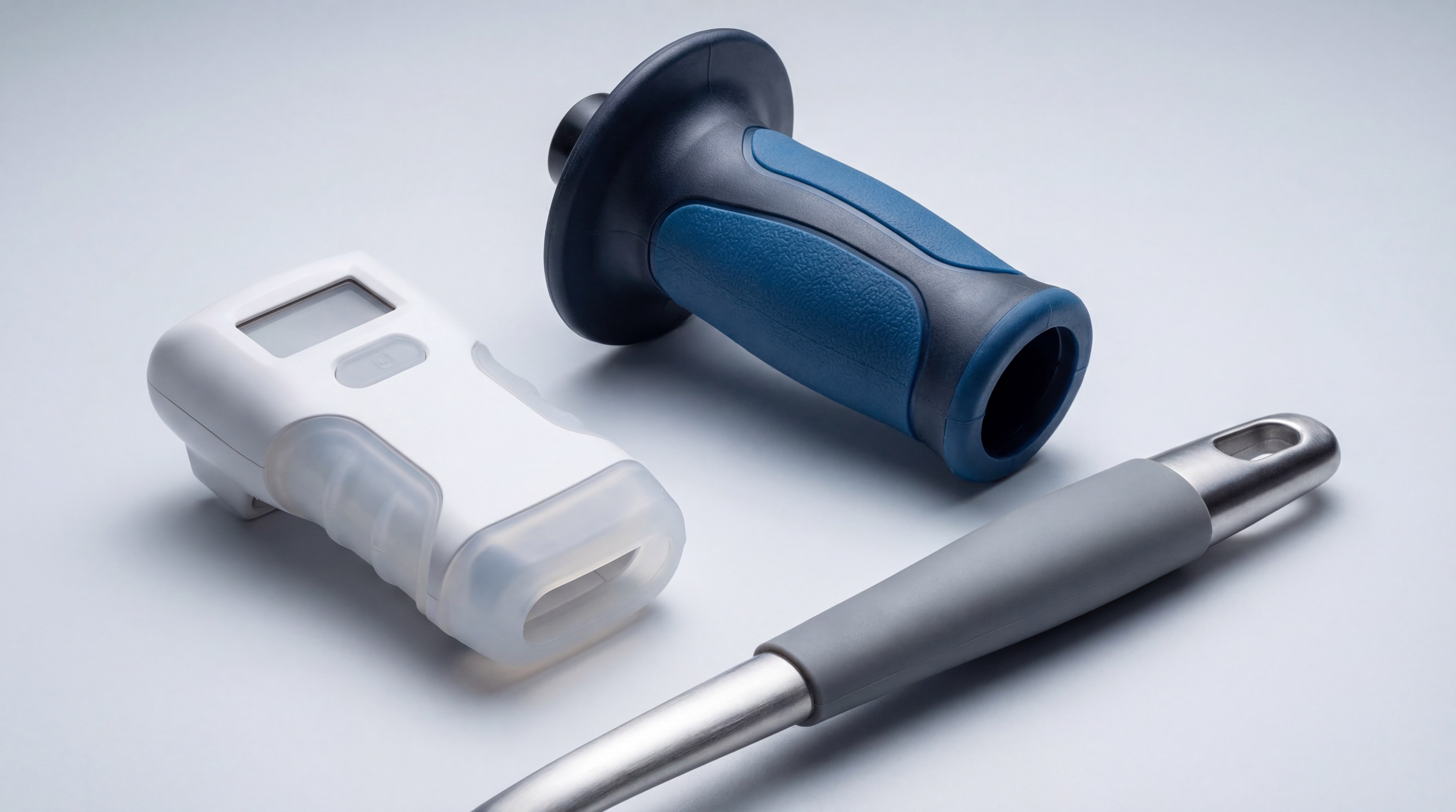 A display of various silicone over-molded products including a kitchen tool handle and an electronic device case.