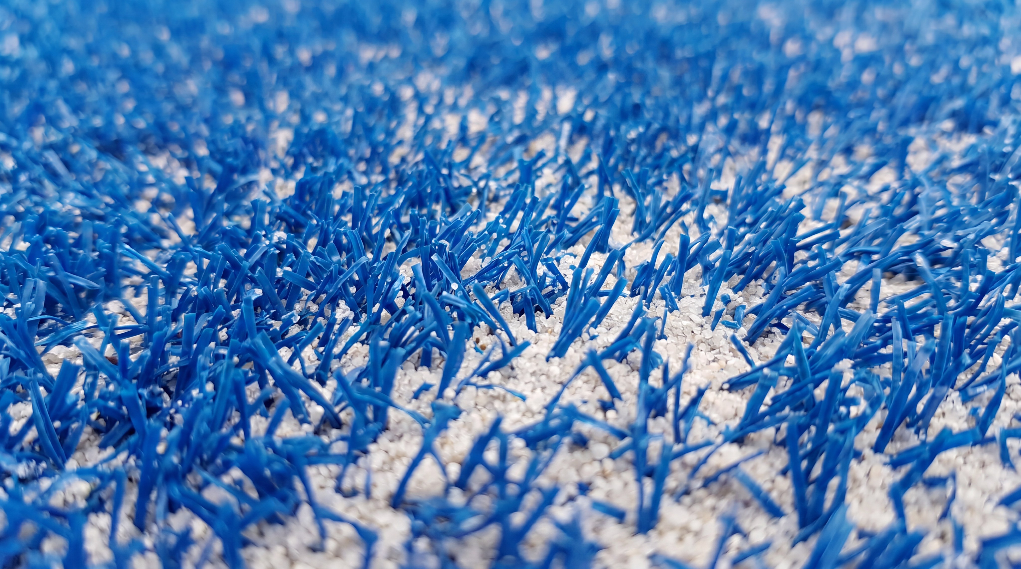Extreme close-up of high-density blue padel court artificial turf