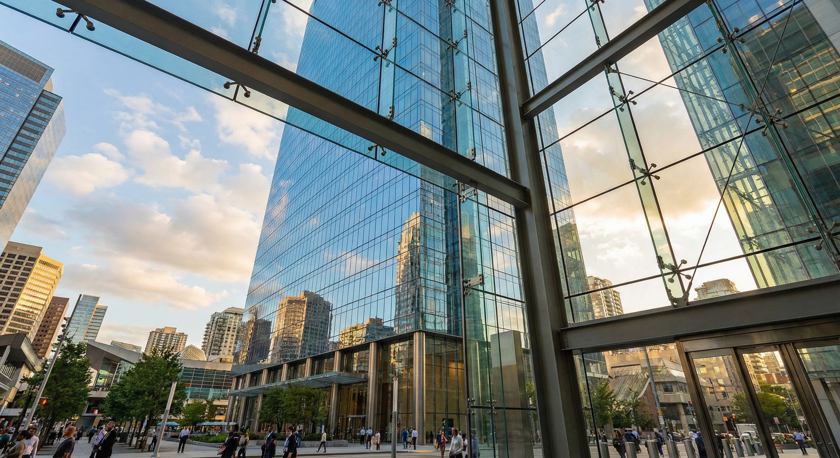 Wide angle shot of a modern glass skyscraper with a full curtain wall reflecting the city sky.