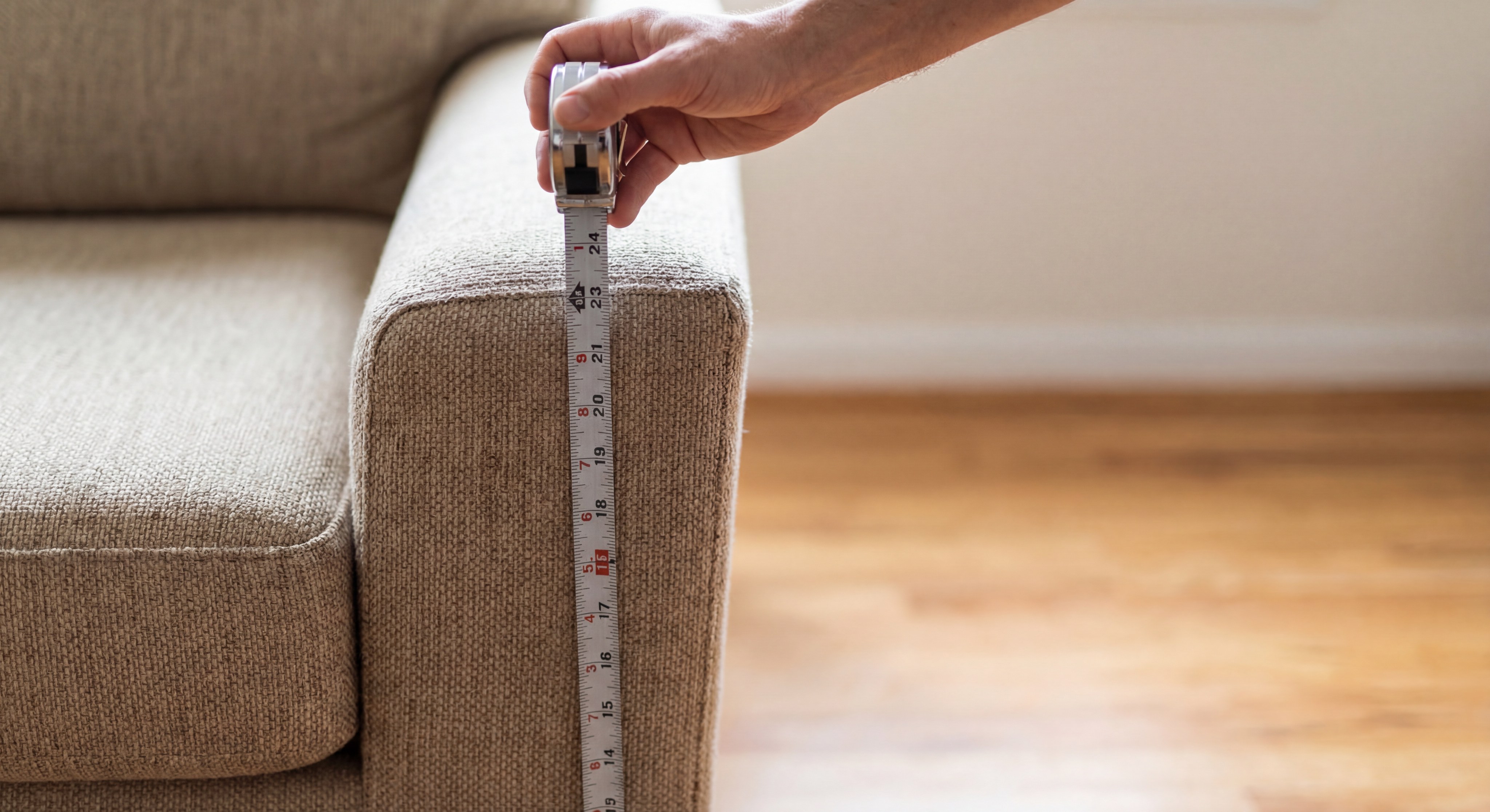 Measuring sofa arm height with a steel tape measure