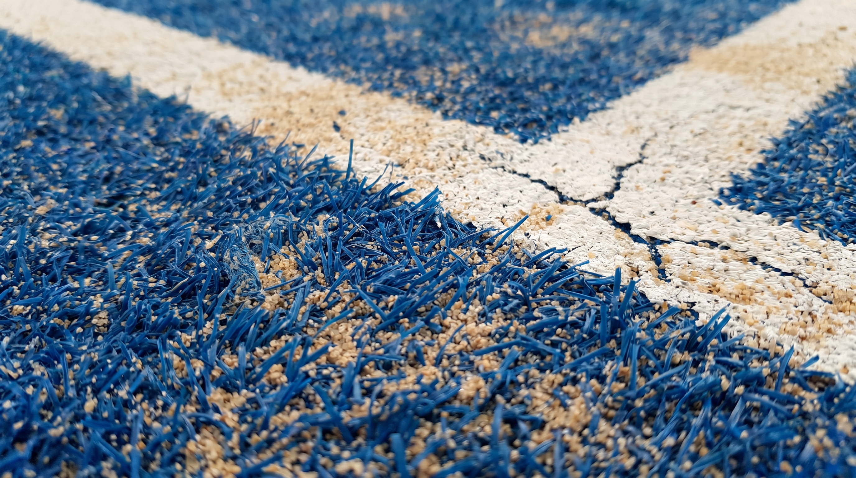 close-up of blue textured padel turf with sand infill