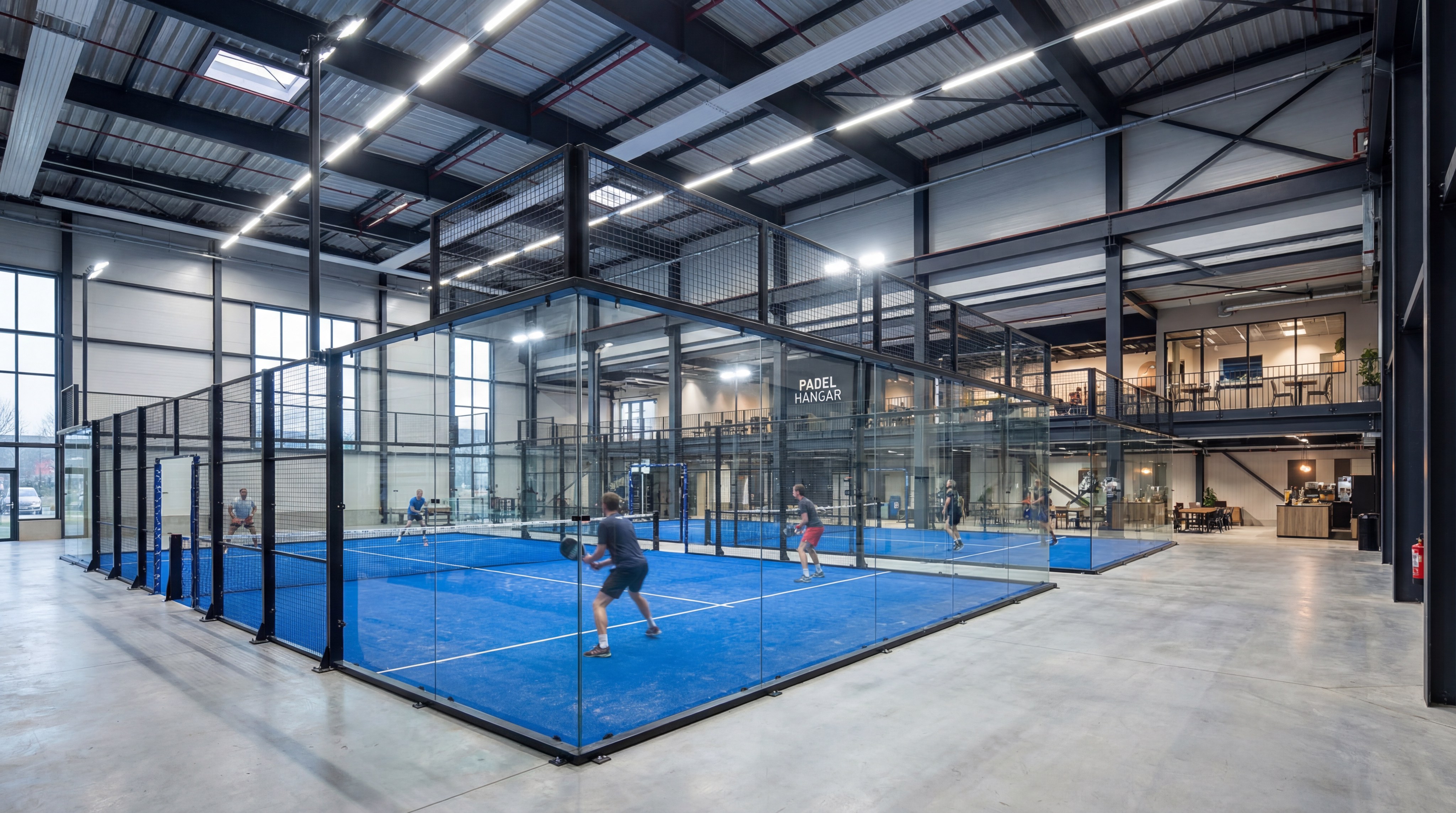 An indoor padel facility with multiple courts and modern industrial lighting.