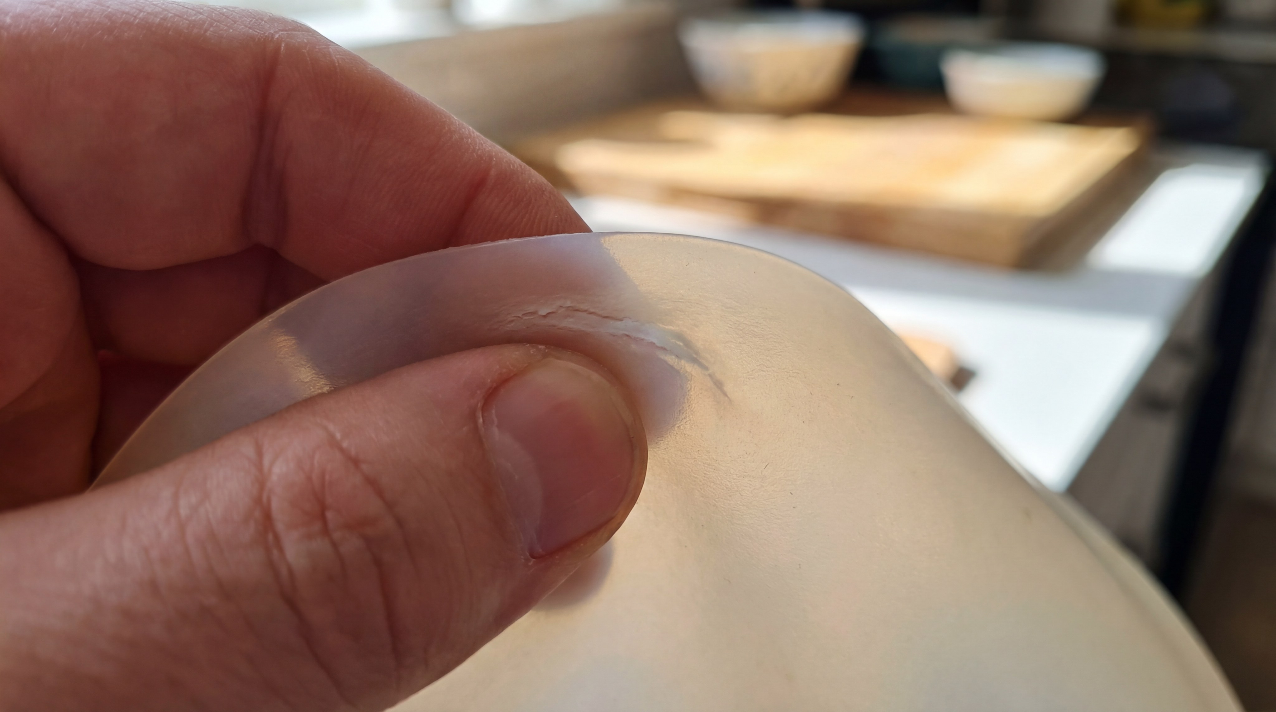 A close-up of a hand performing the pinch test on a silicone mat