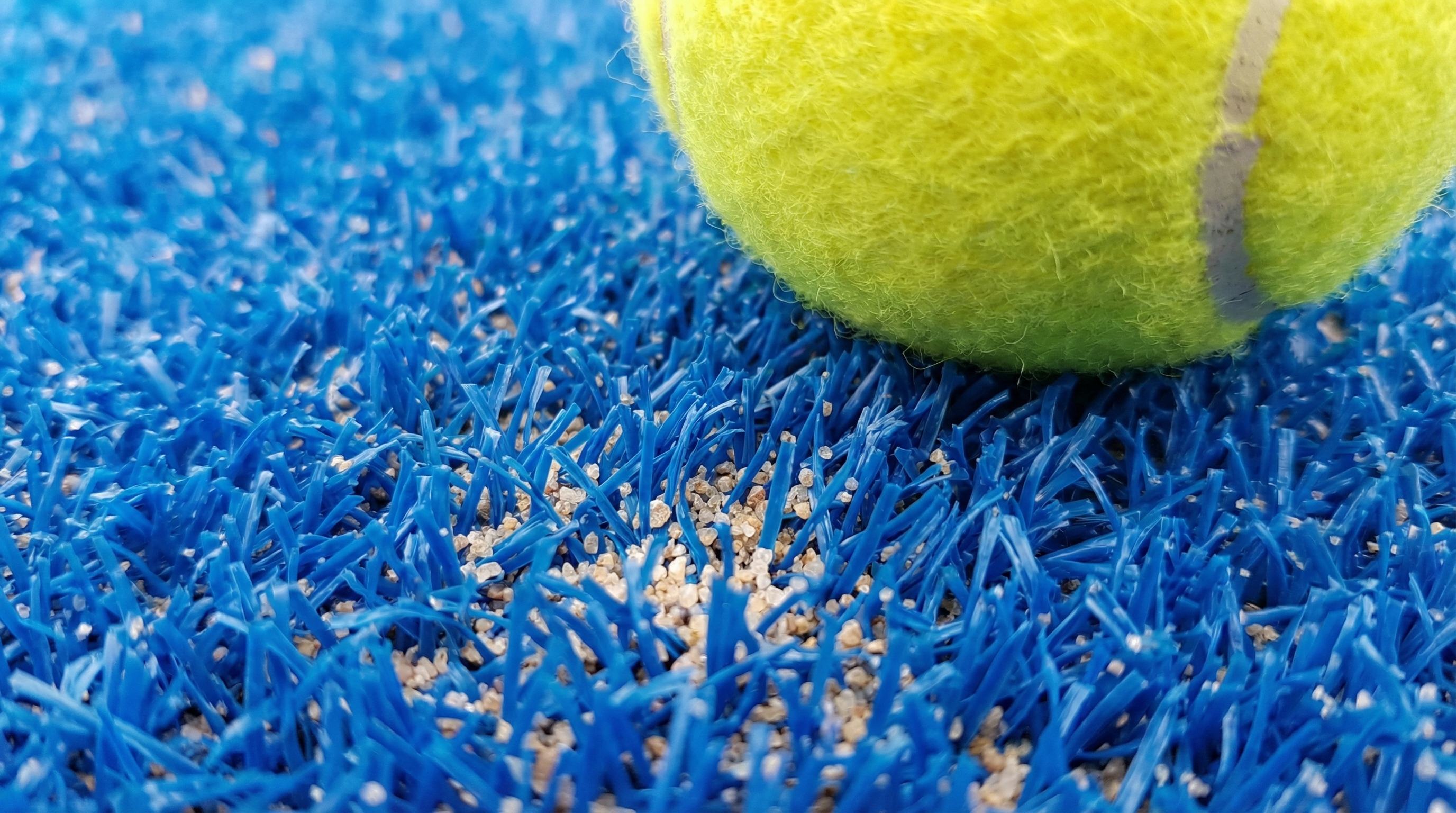 macro shot of blue synthetic turf and sand