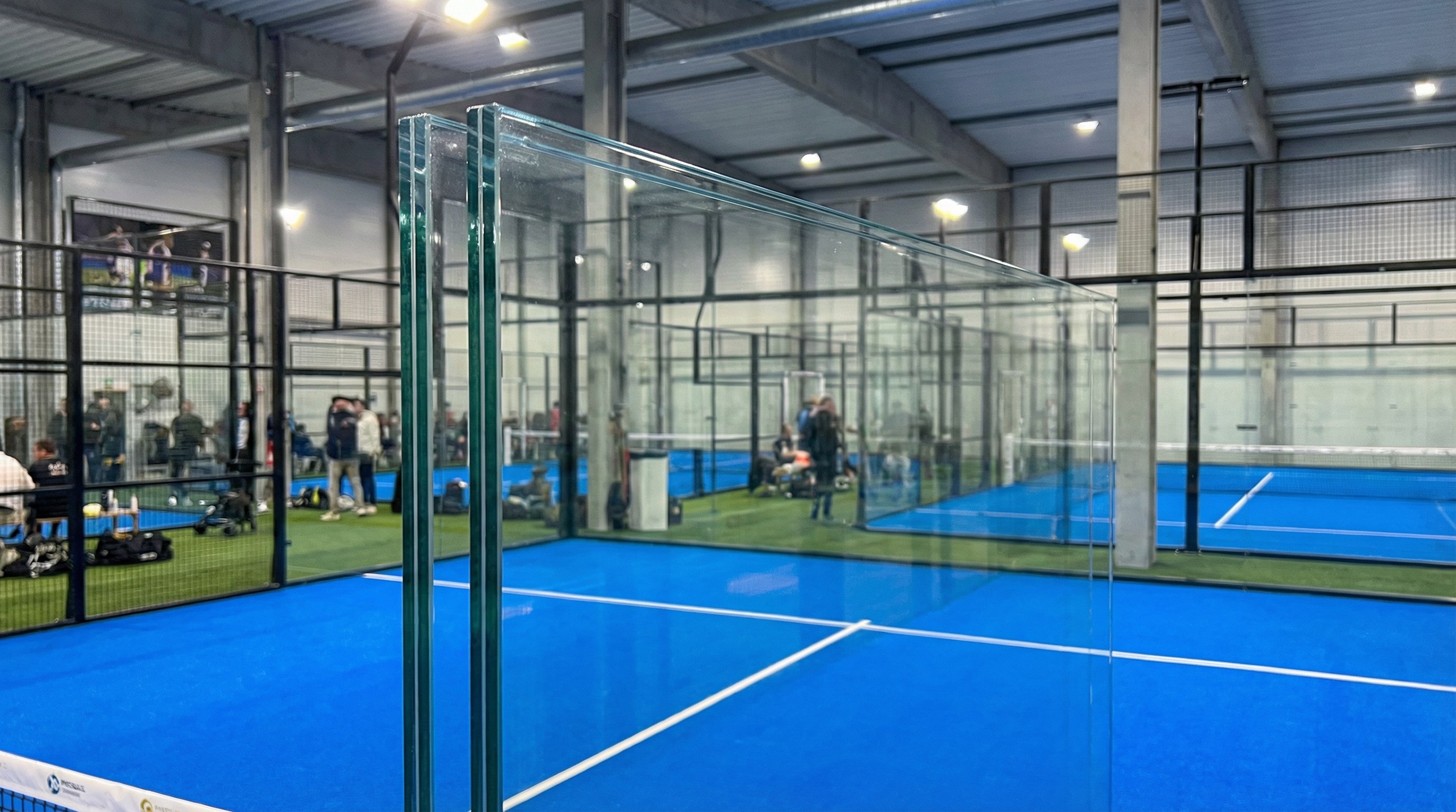A photorealistic image of a 12mm anti-explosion tempered glass panel being installed, with the NYC skyline reflected in its clear surface.