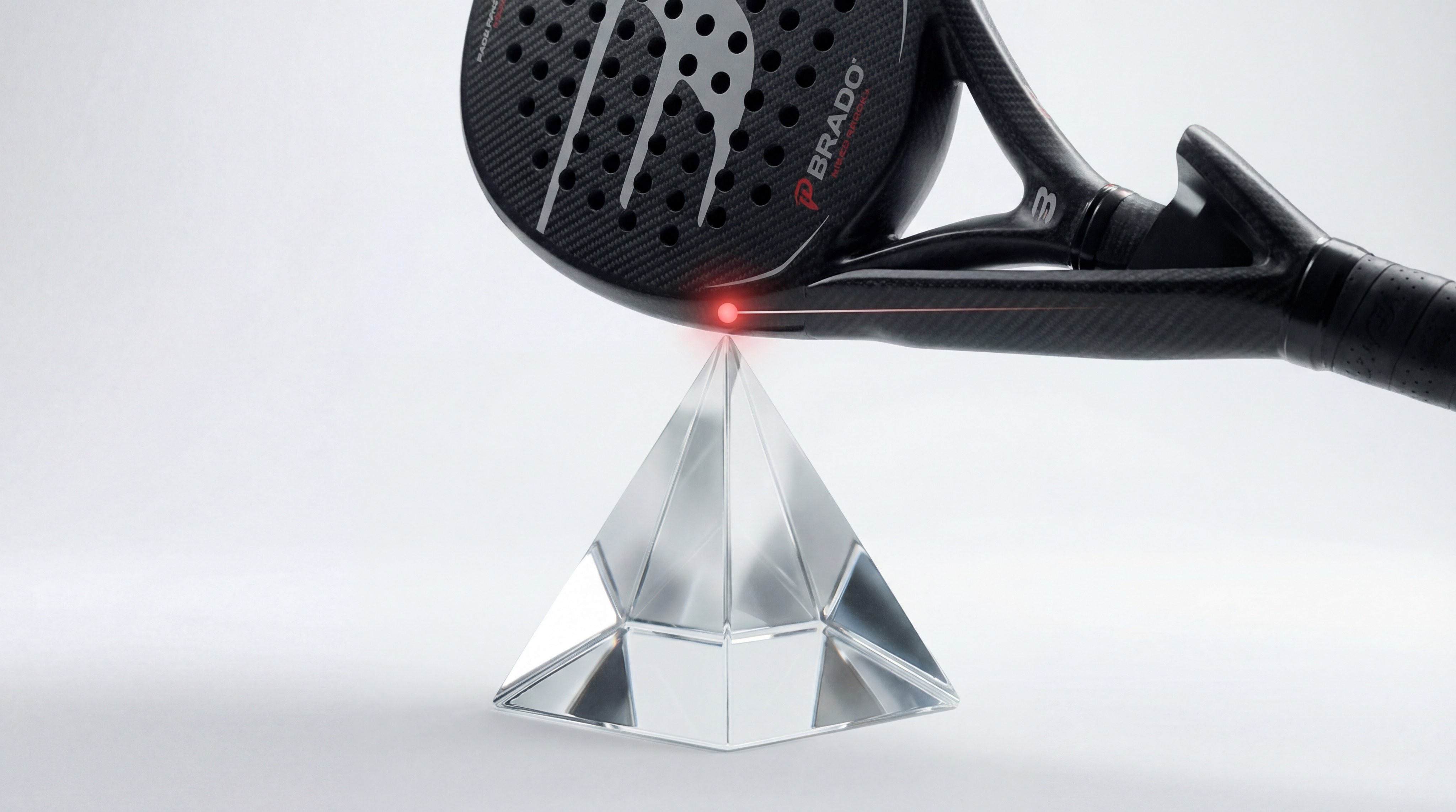 technical shot of a padel racket balanced perfectly on a glass prism