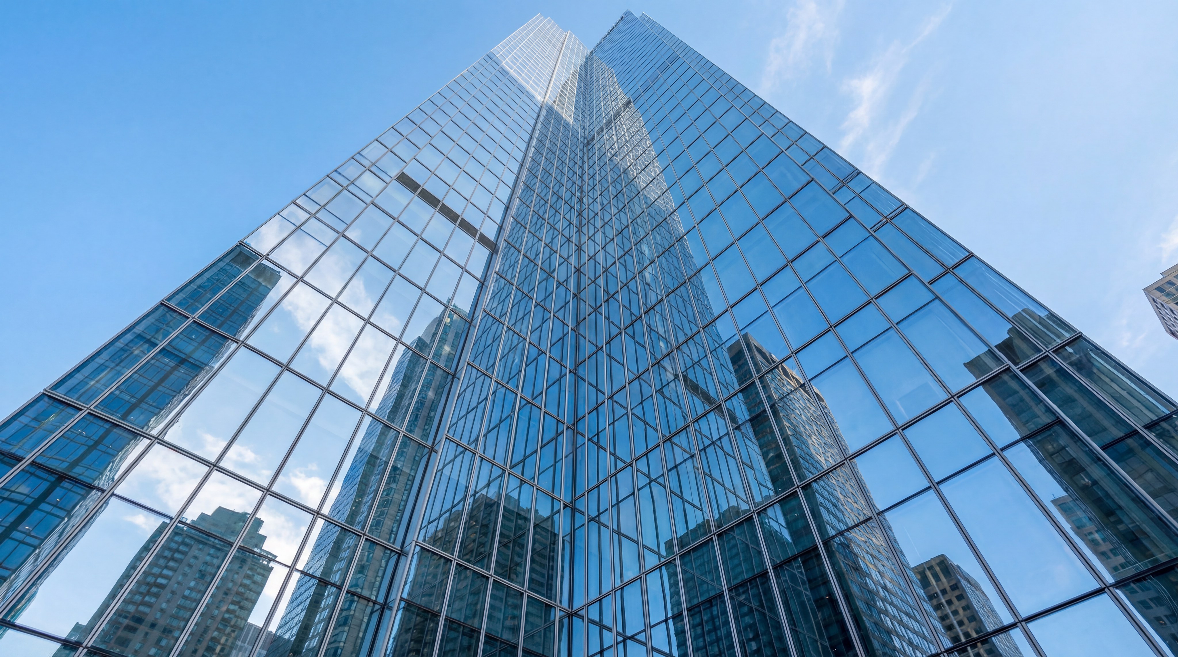 Low angle photorealistic shot of a modern skyscraper's glass curtain wall, reflecting the blue sky, highlighting the scale and weight of the glass panels used in construction.